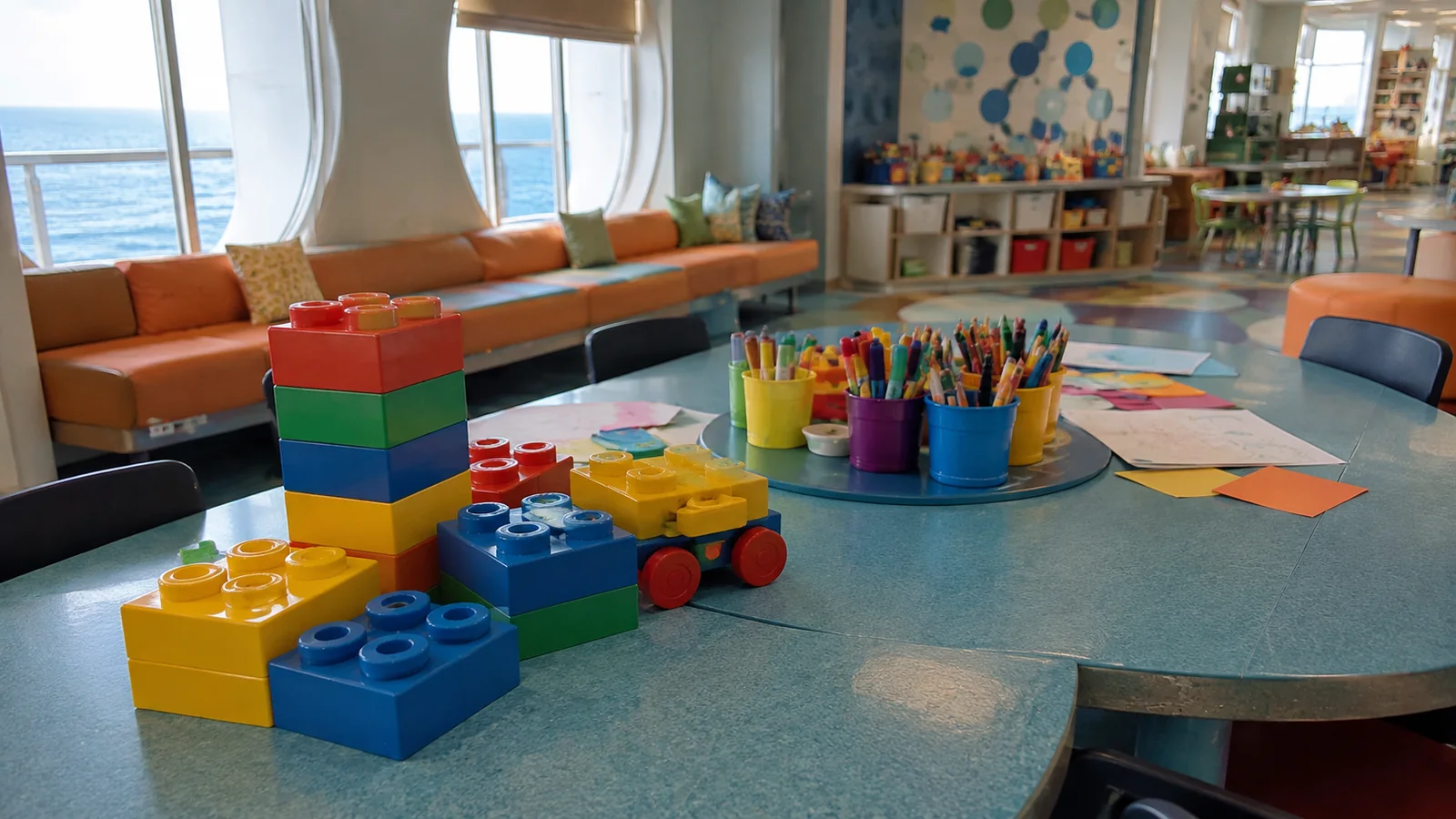 Colorful building blocks, paper, and pencils spread across a craft table.
