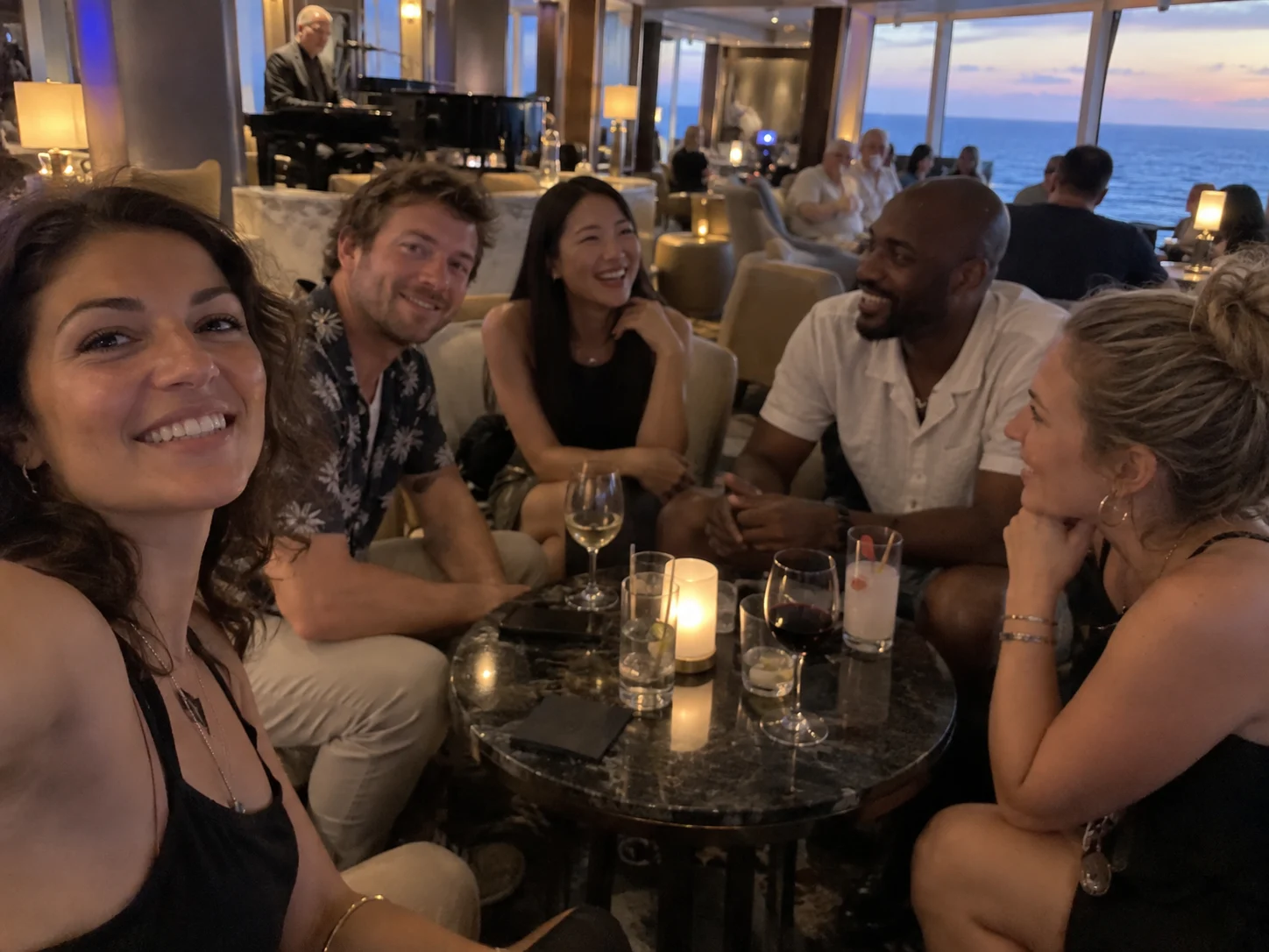 Solo travelers meeting around a table in a cruise ship lounge.