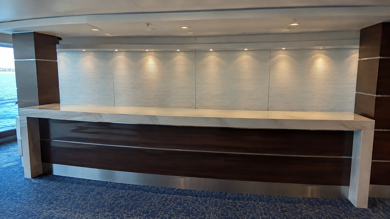 Empty reception counter stands beside windows overlooking the ocean.