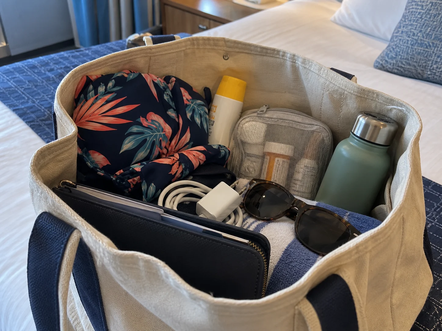 Cruise embarkation carry-on with swimsuit, sunscreen, medicine, charger, and documents
