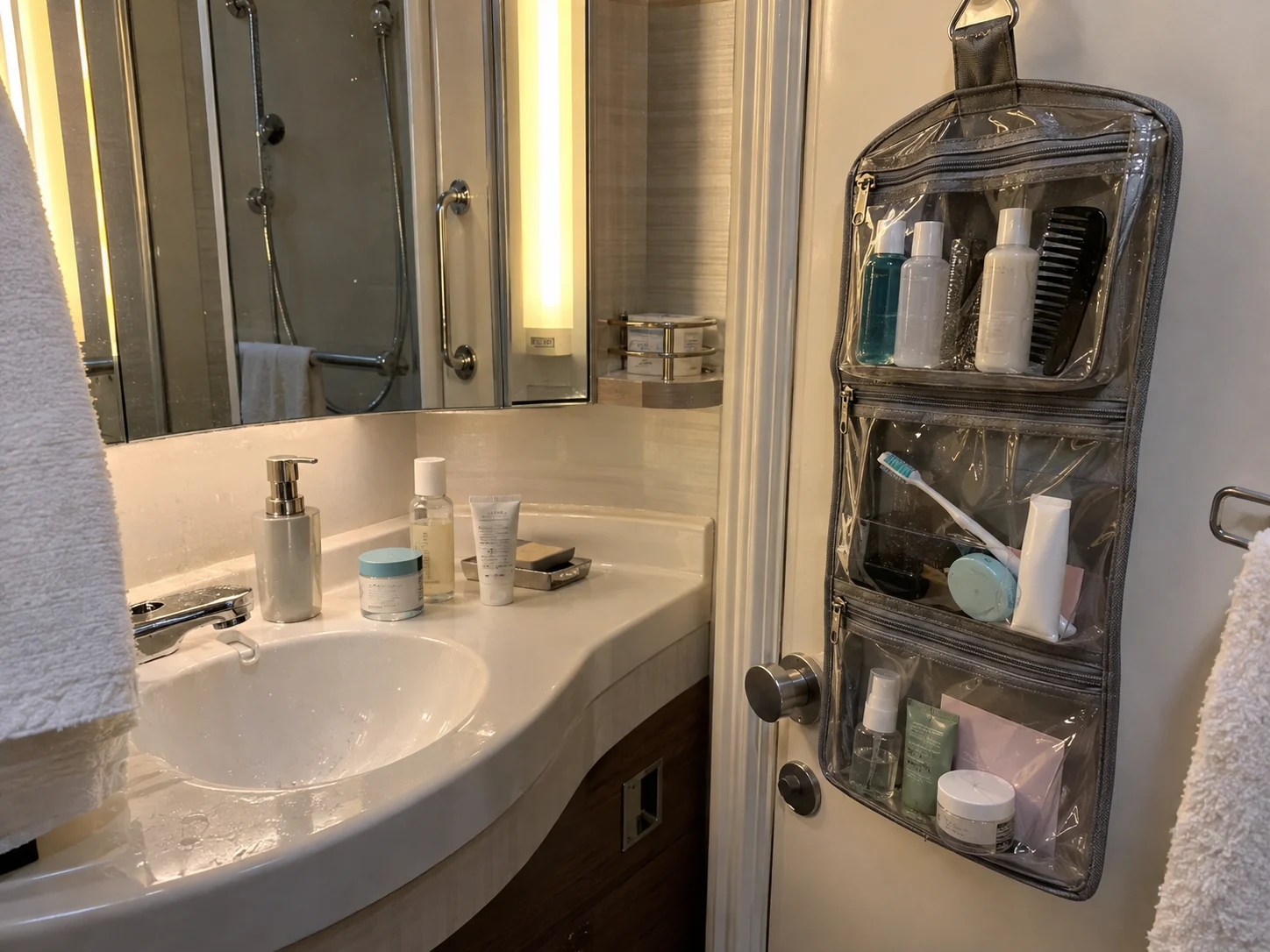 Travel-size toiletries organized in a clear hanging bag in a cruise cabin bathroom