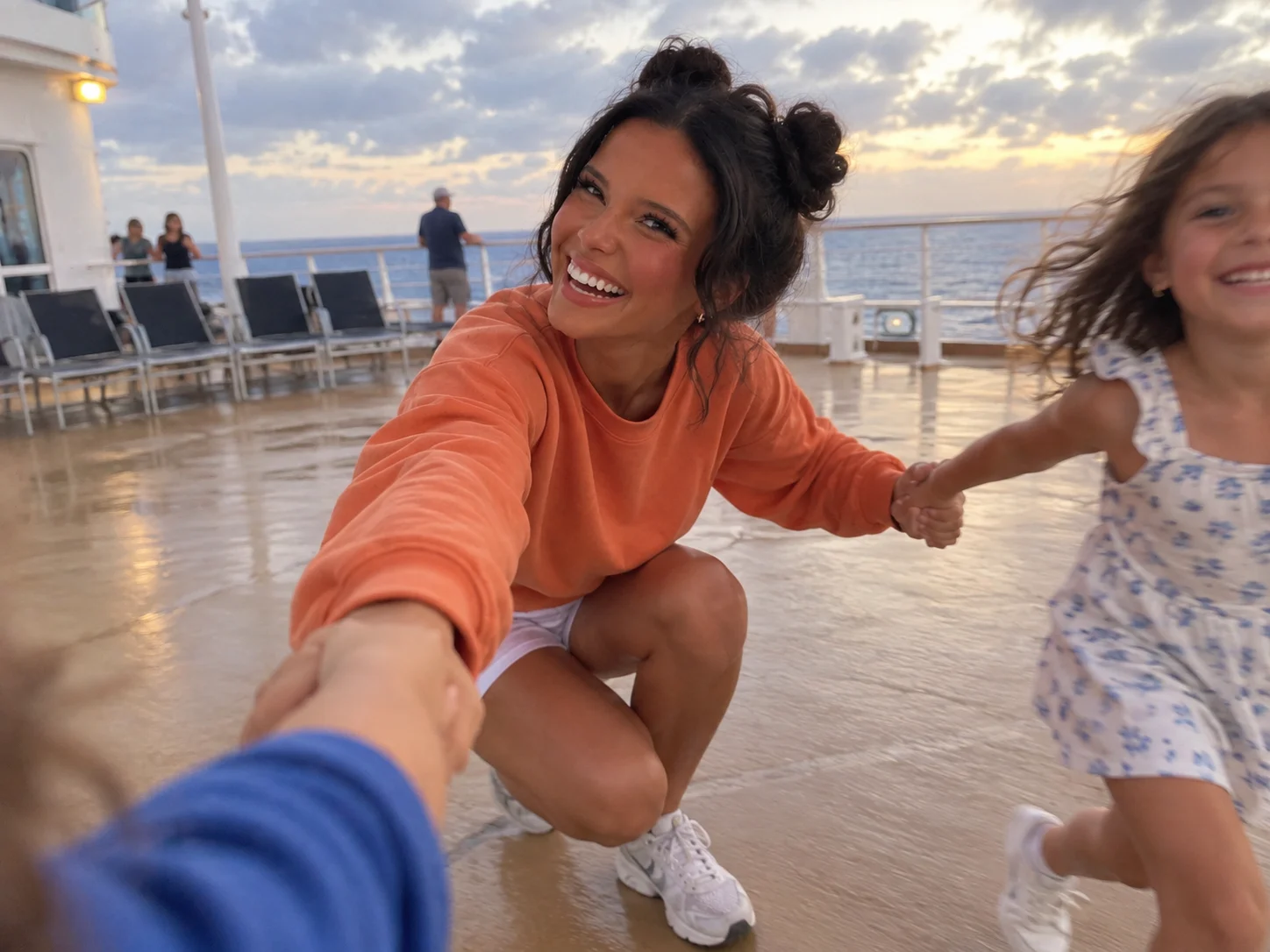 Ellie laughs as children lead a playful deckside movement photograph.