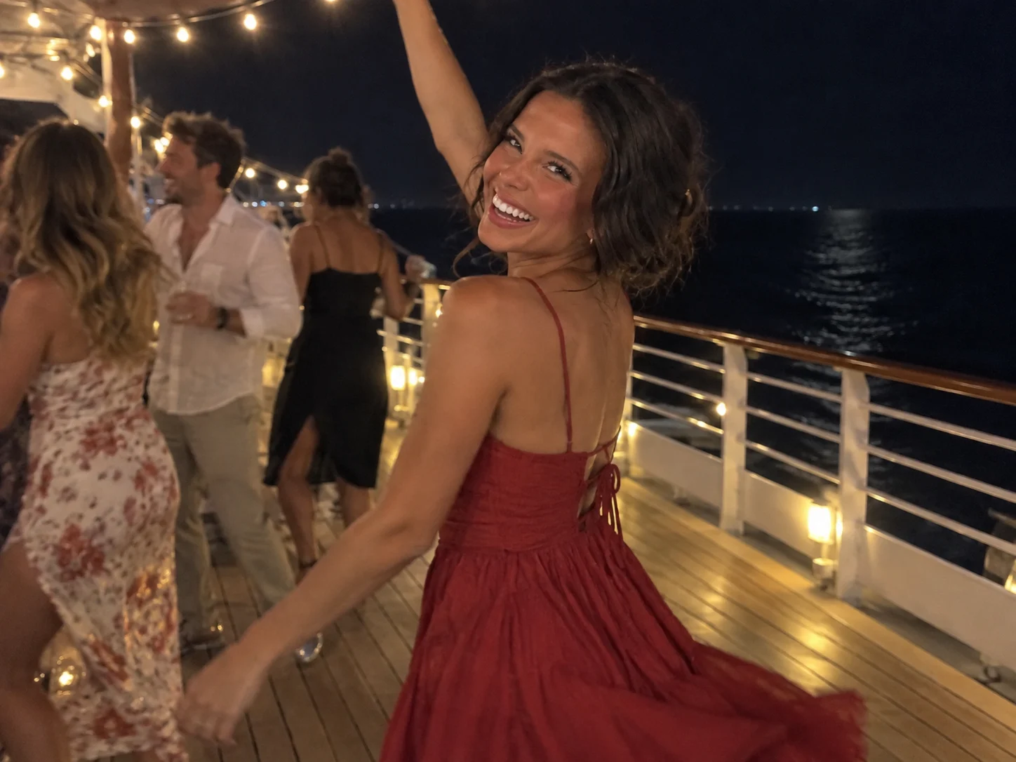 Ellie turns through a short dance movement beneath evening deck lights.