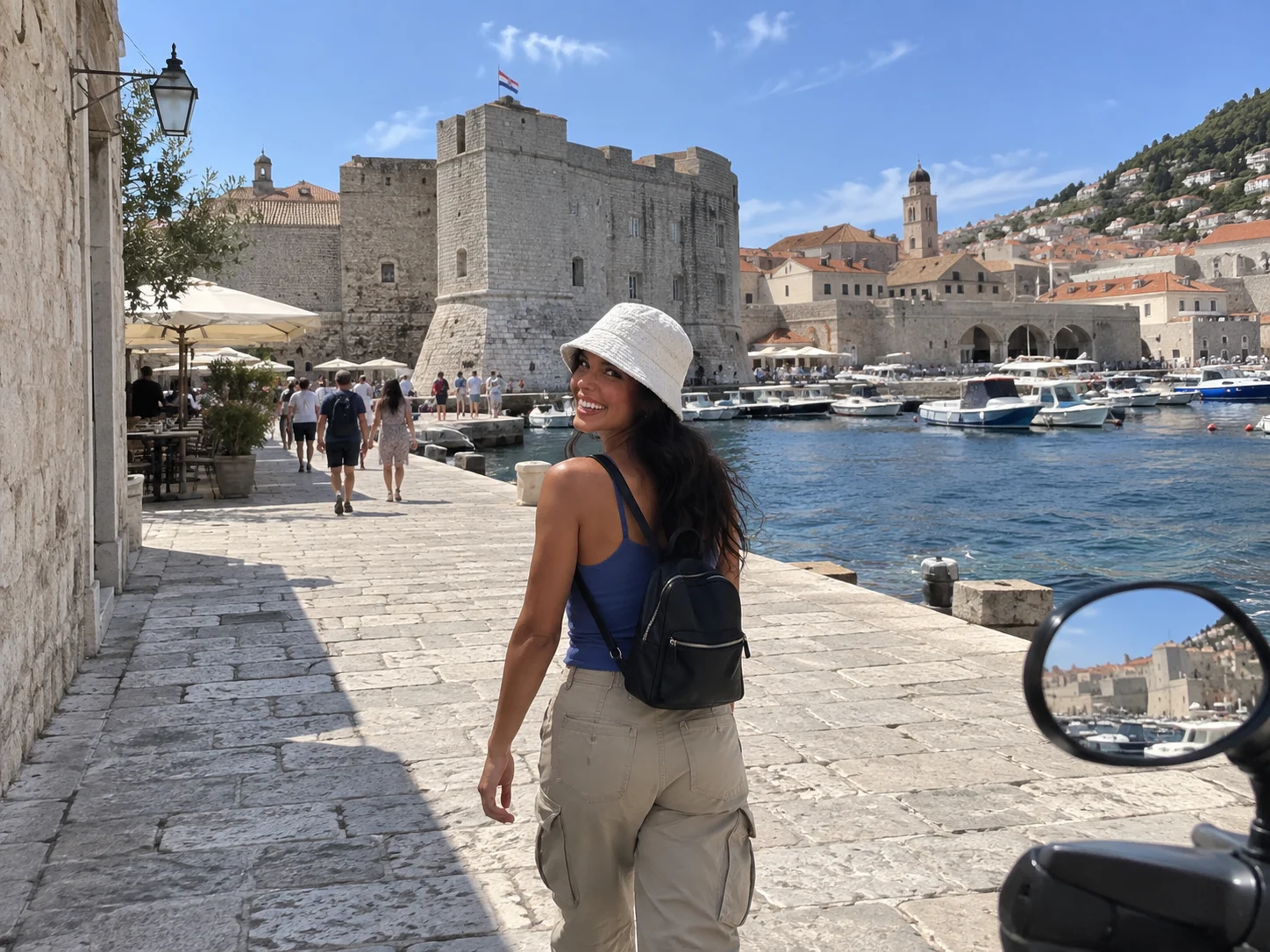 Ellie appears small within a wide port view that includes a historic landmark.