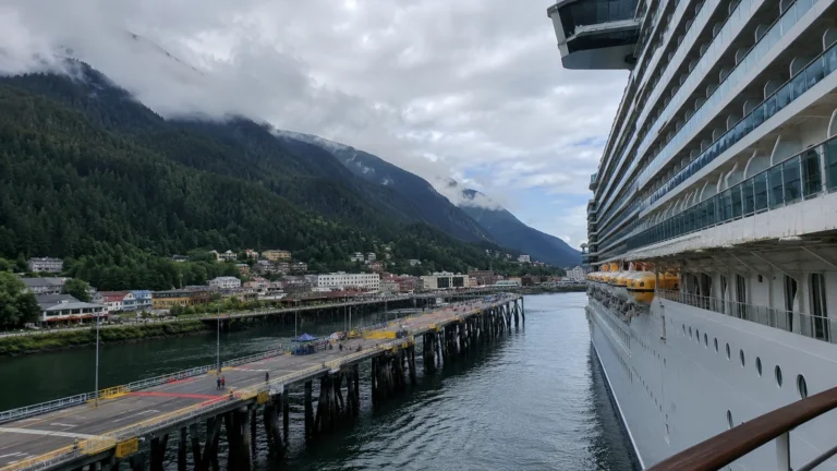 Cruise ship docked in a mountain harbor beside a town