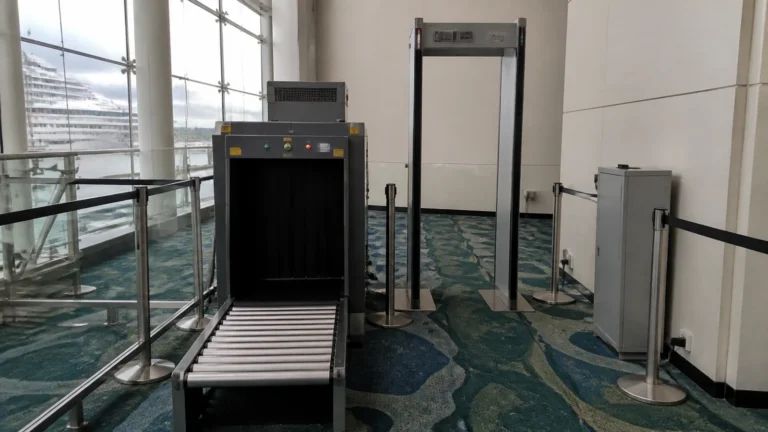 Empty baggage scanner and queue barriers stand in a terminal.