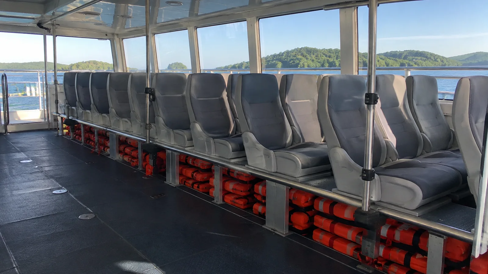 Empty tender seats have orange life jackets stored underneath.