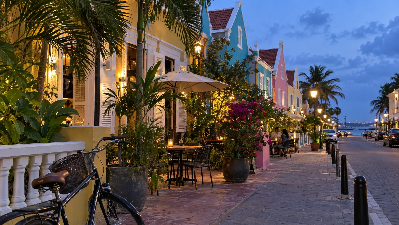Colorful historic buildings, sidewalk cafés, and a bicycle in Pietermaai, Curaçao, at blue hour