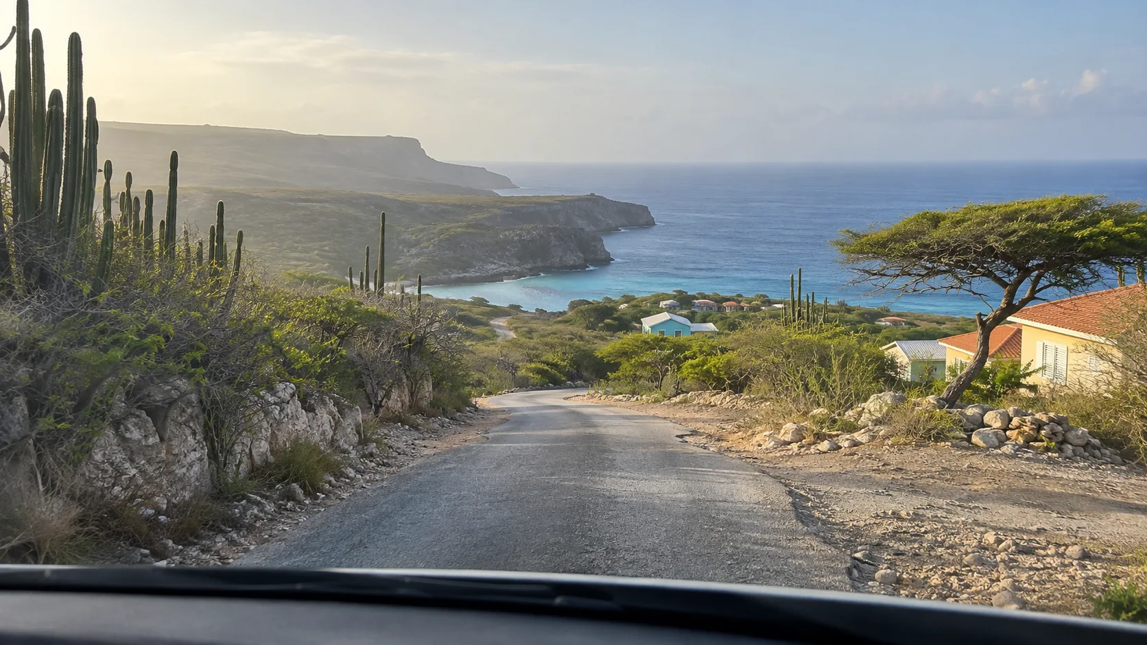 Quiet road through cactus-covered hills descending toward the sea near Westpunt, Curaçao