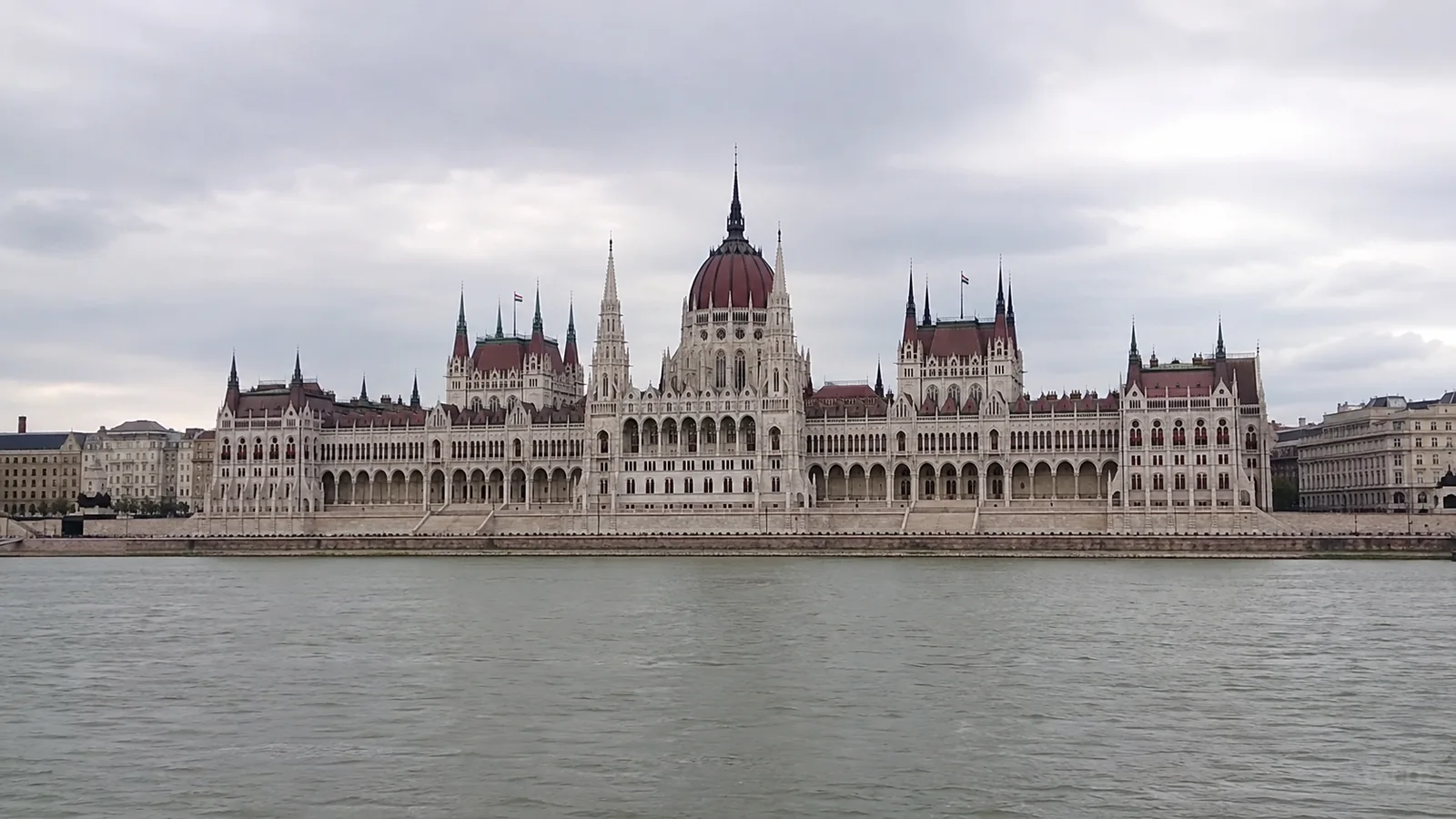 Large ornate domed building with pointed towers lining the opposite riverbank.