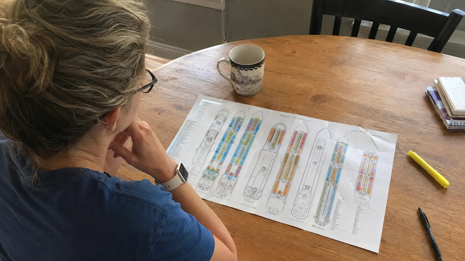 Traveler marking a printed ship deck plan with a highlighter.