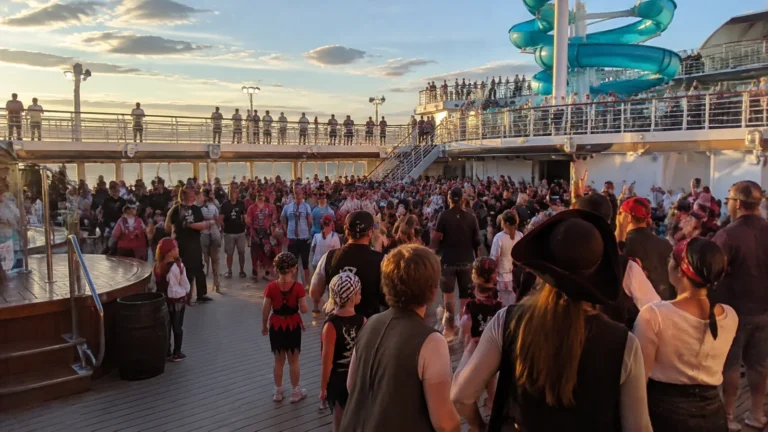 Passengers gathering for an evening party on a cruise ship's pool deck.