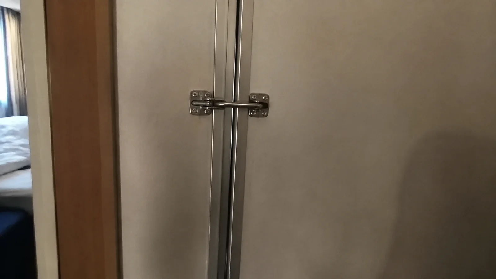 Close view of a metal latch securing an interior door.