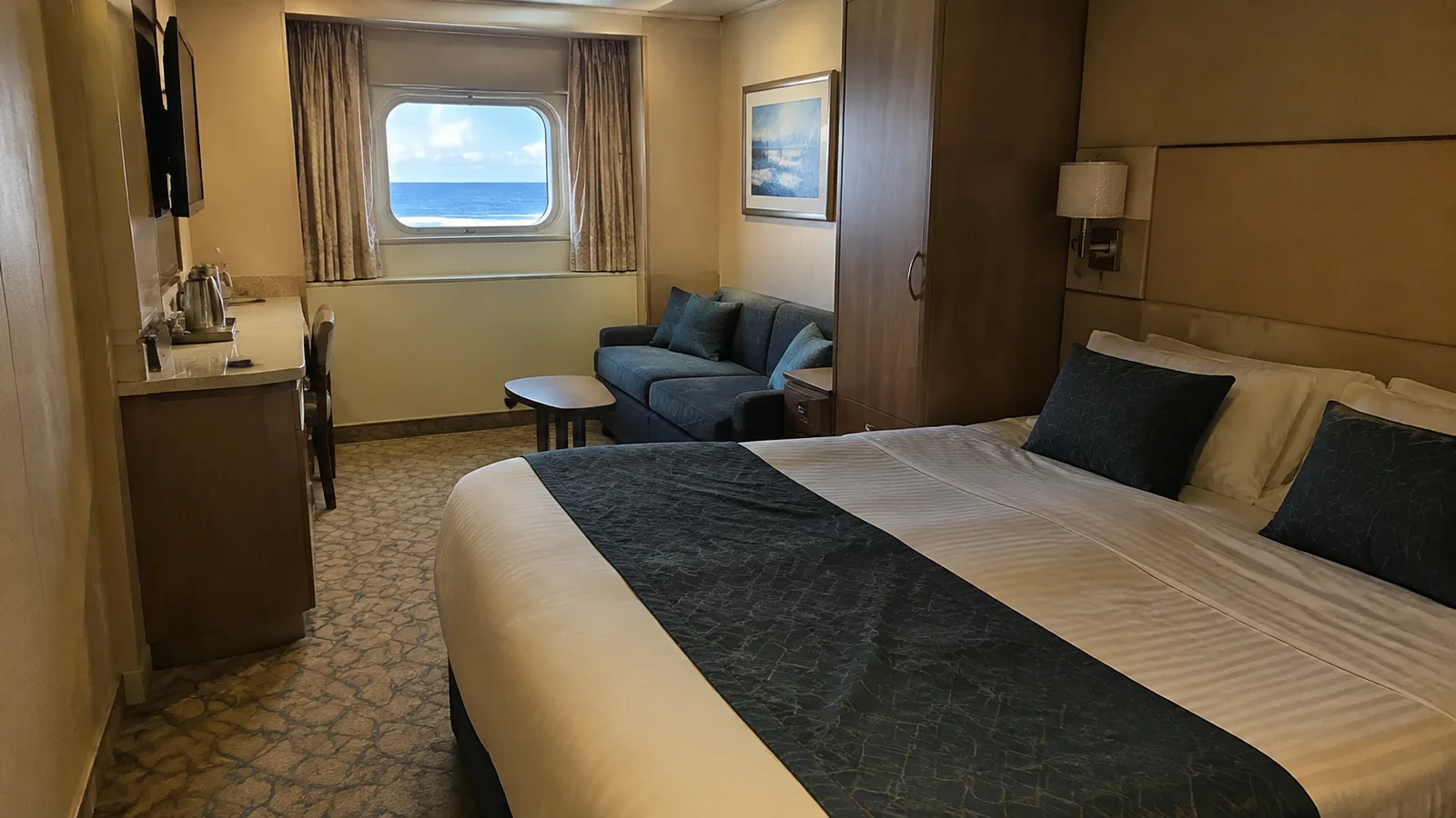 Oceanview stateroom contains a double bed, sofa and desk.