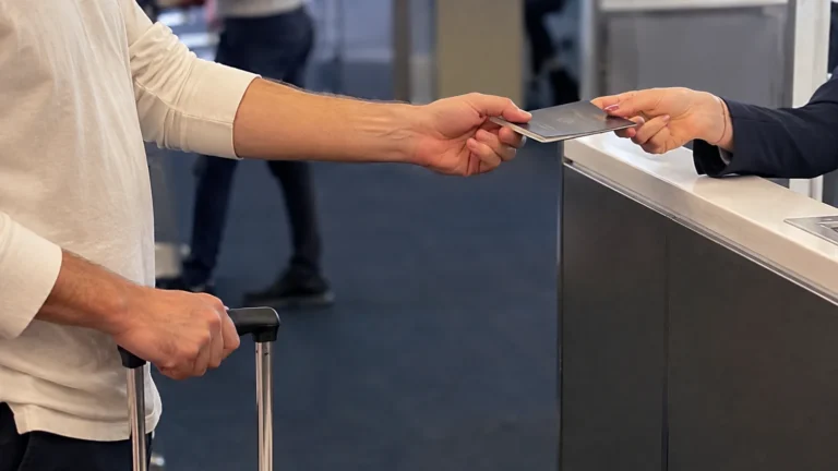 Traveler handing a passport across a terminal check-in counter.