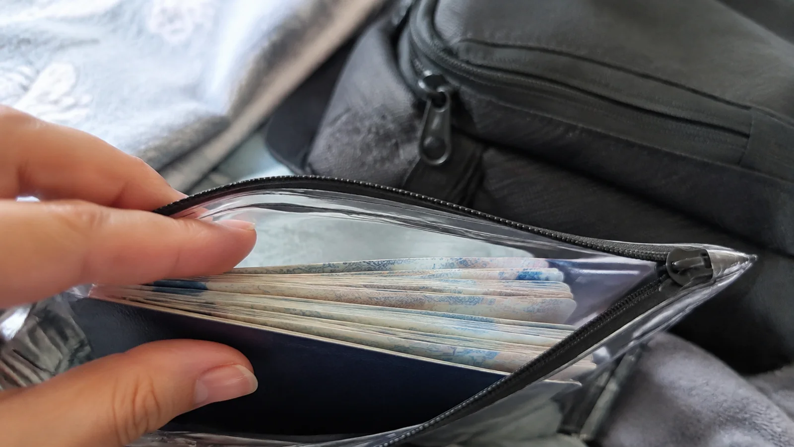 Passport and papers organized inside a zippered document wallet.