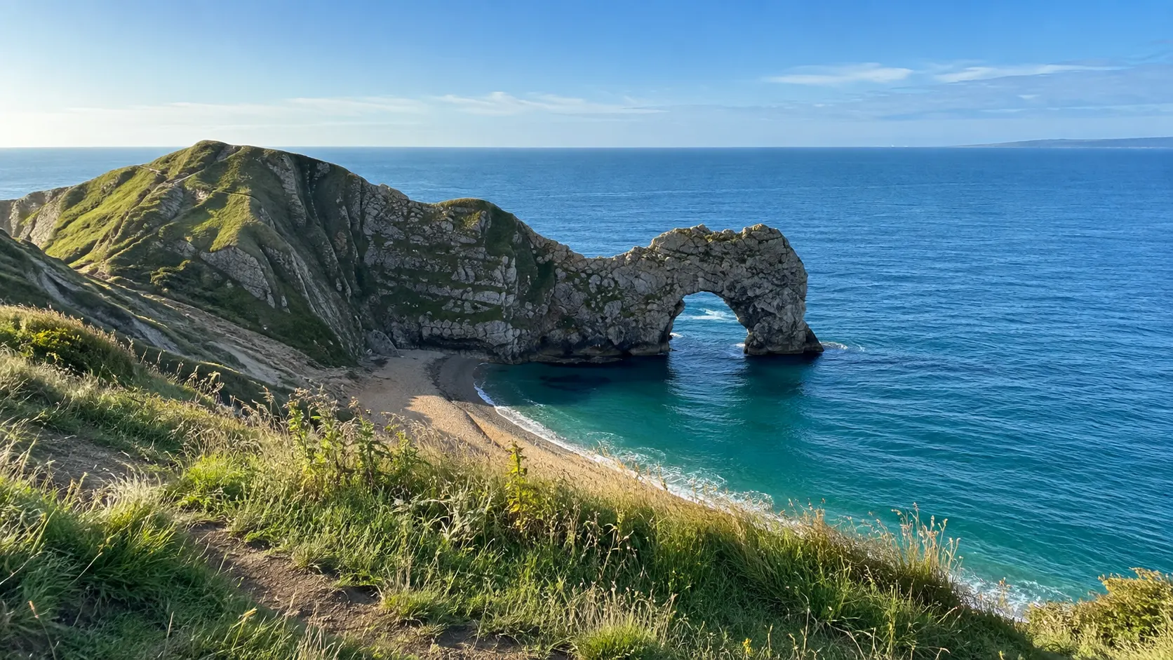 Durdle Door limestone arch rising from the blue sea on Dorset's coast.