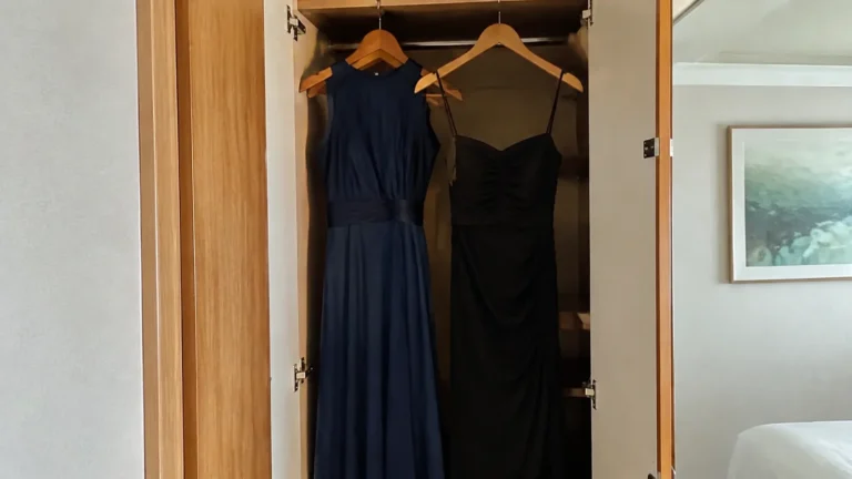 Navy and black evening dresses hanging in a cruise cabin wardrobe
