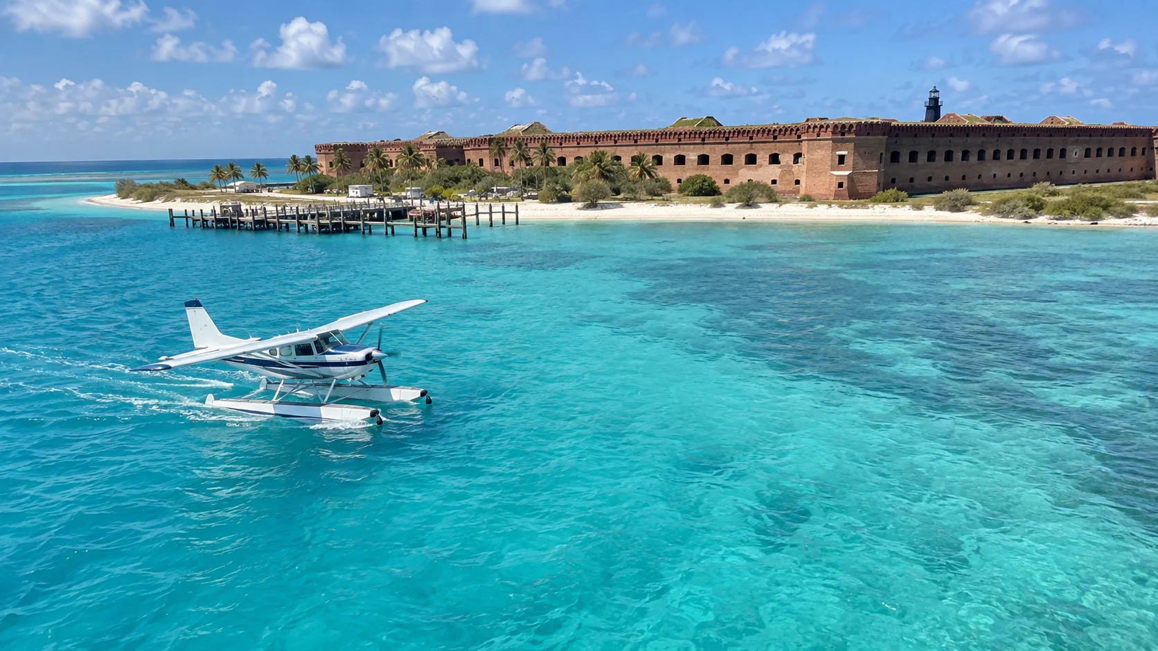 Floatplane taxiing on turquoise water near Garden Key.