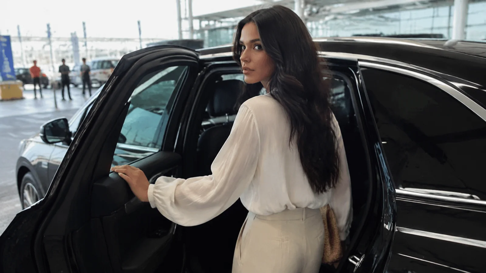 Woman getting into a car outside a cruise terminal.