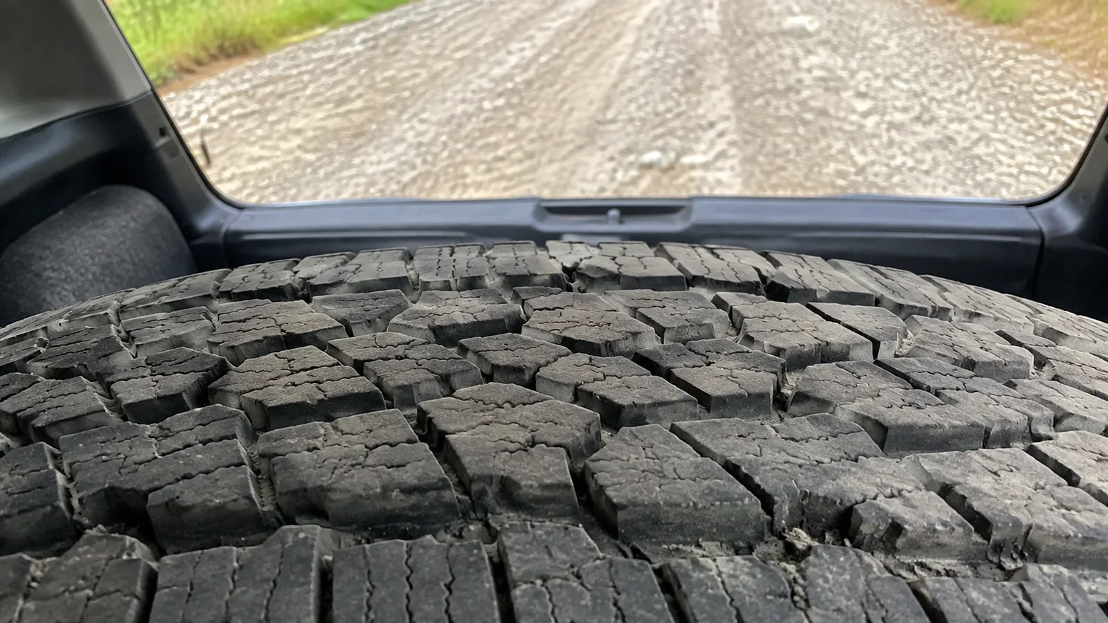 Close view of chunky tread on a spare tire in a vehicle.