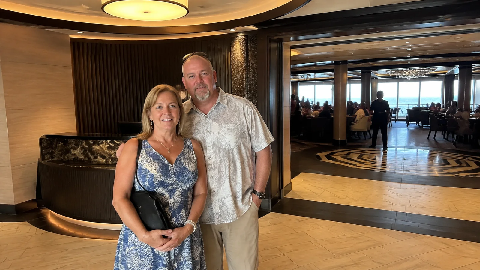 Couple stands together near the entrance to a ship restaurant.