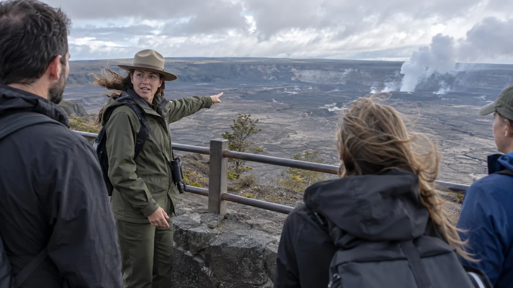 Park ranger leading a visitor program at a dramatic volcanic overlook
