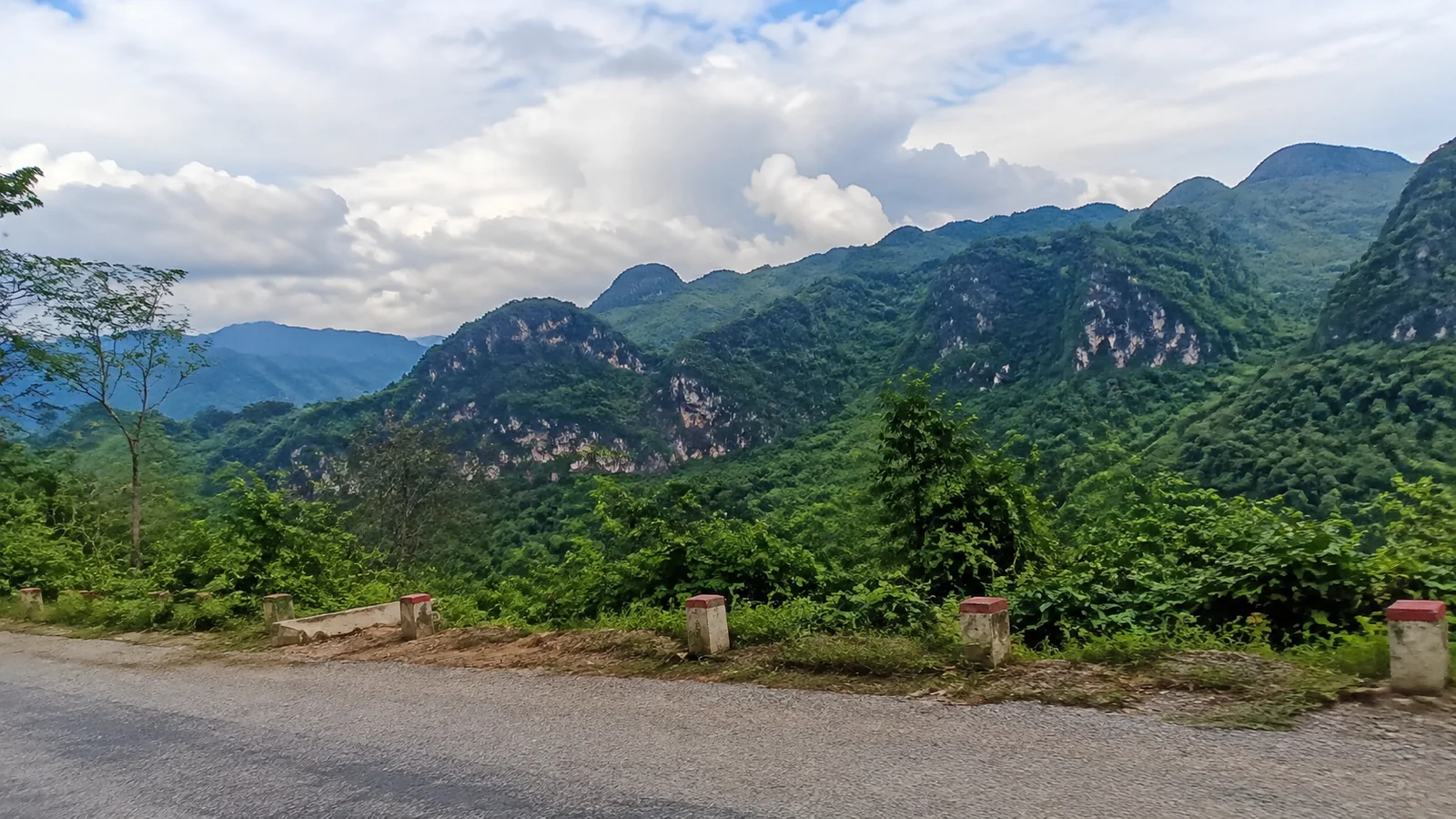 Lush mountain ridges spread beyond a roadside overlook.
