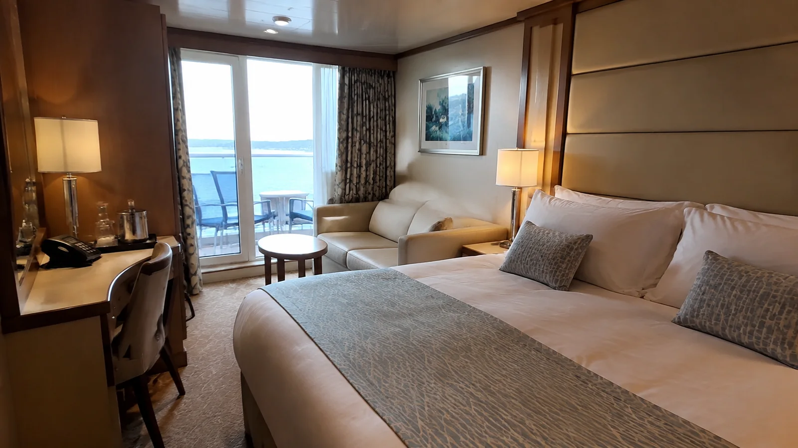Balcony cabin with a double bed, sofa and small table.
