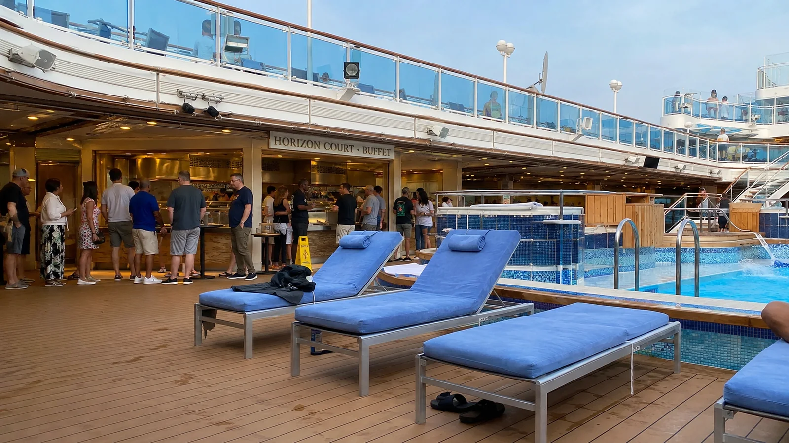 Blue loungers beside a ship pool and an open-air bar.