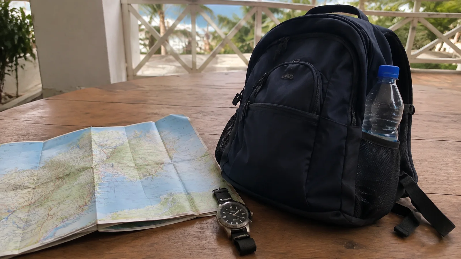 Backpack, water bottle, watch and map ready for a shore excursion.