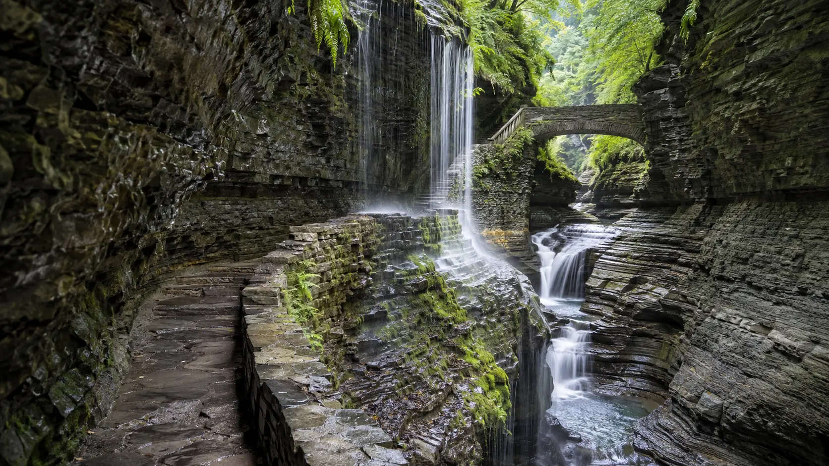 Rainbow Falls flowing beside the stone Gorge Trail at Watkins Glen in New York's Finger Lakes