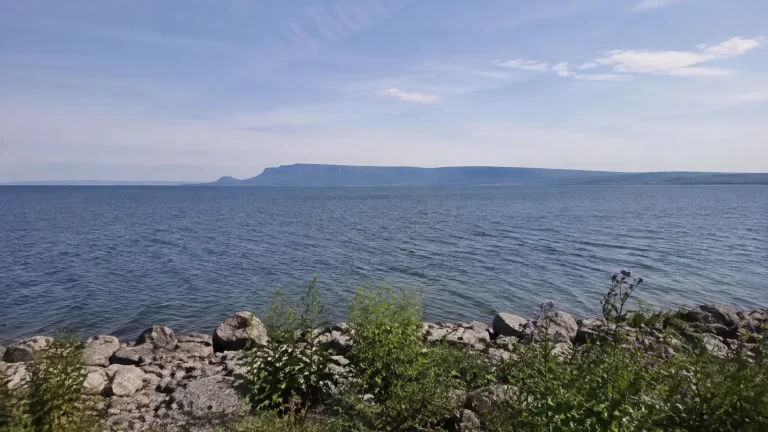 Broad blue lake with a flat-topped rocky landform on the horizon.