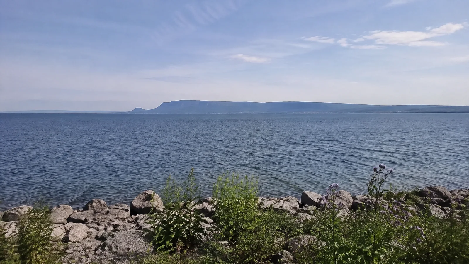 Broad blue lake with a flat-topped rocky landform on the horizon.