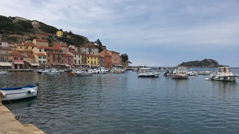 Colorful hillside buildings and small boats surrounding a sheltered harbor