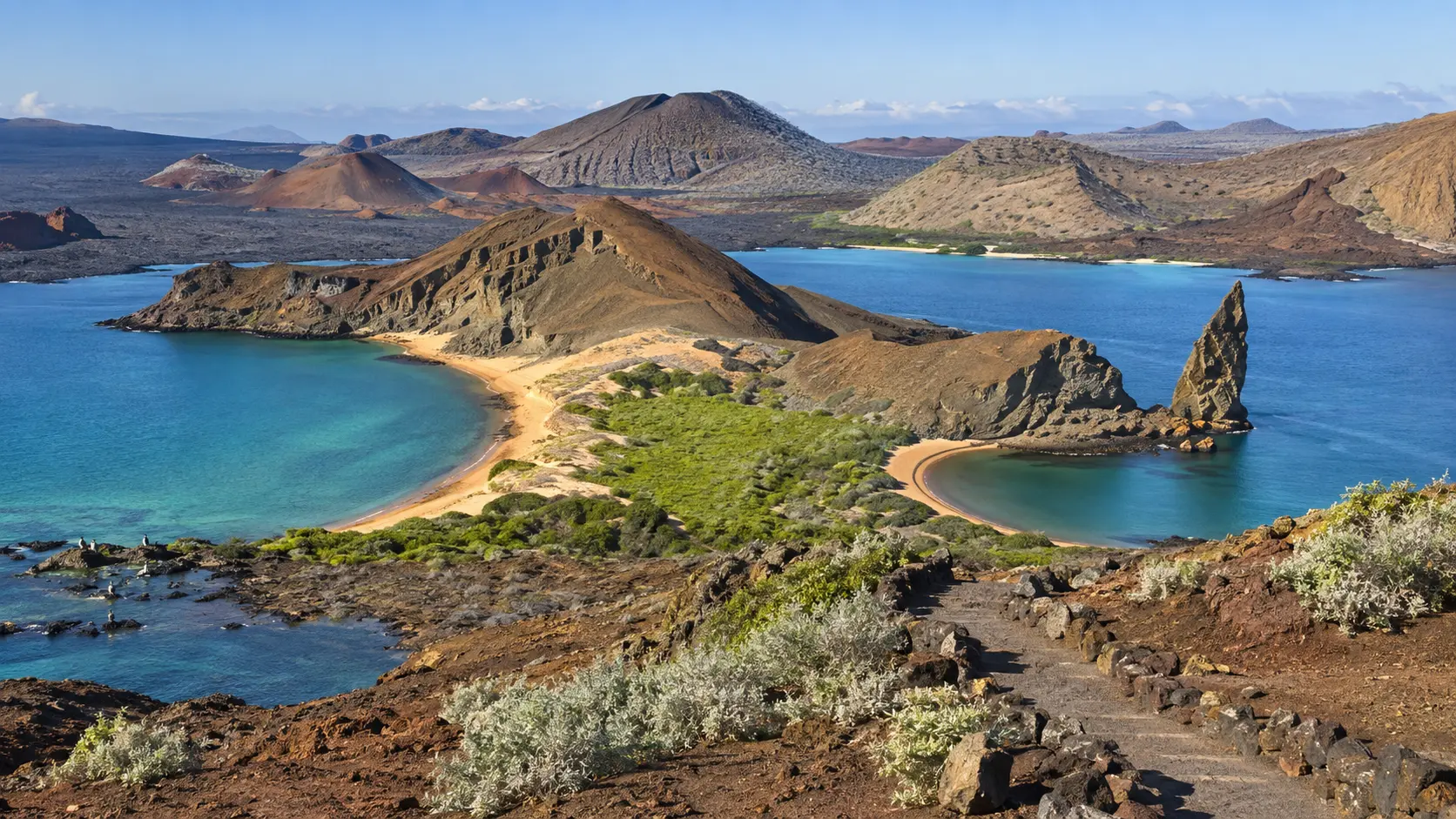 Pinnacle Rock, volcanic cones and turquoise bays spread below Bartolomé Island in Galápagos National Park.