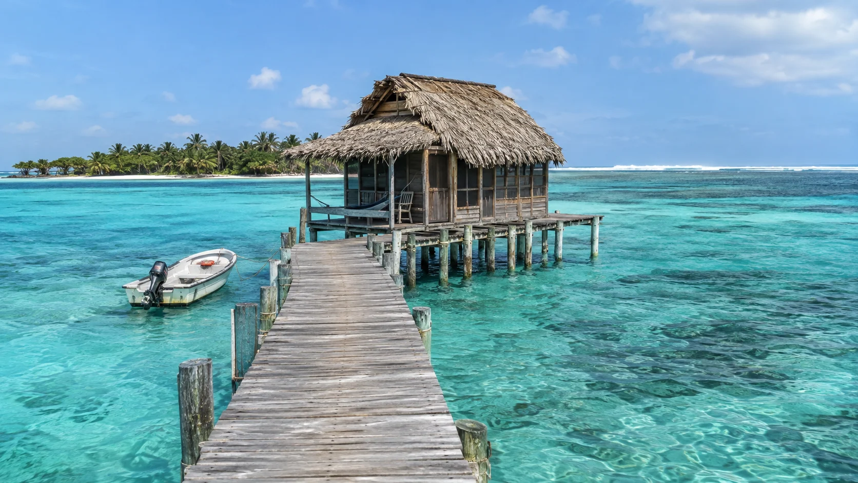 Rustic thatched overwater cabana and skiff at Glover's Atoll Resort in Belize.