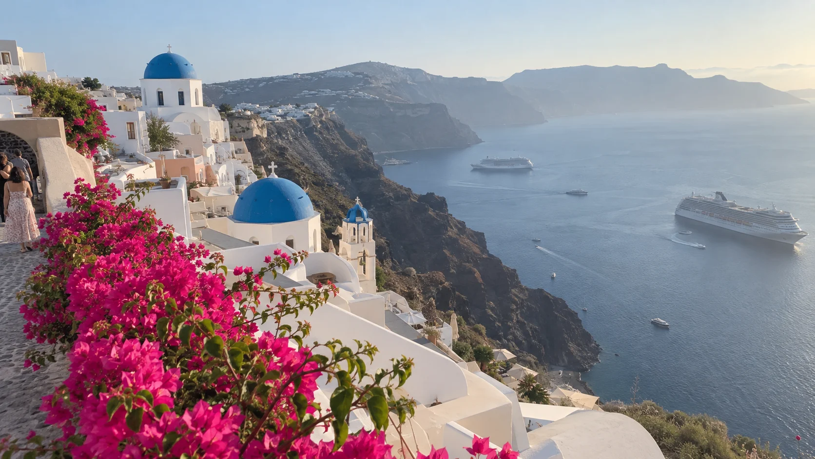 Whitewashed Santorini village on volcanic cliffs above a deep blue caldera.