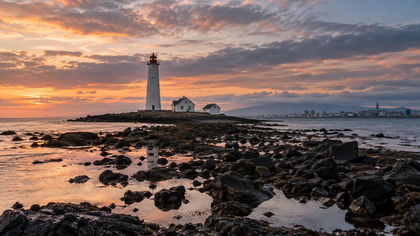 Grótta Lighthouse and keeper buildings on a rocky tidal islet near Reykjavík at sunset.