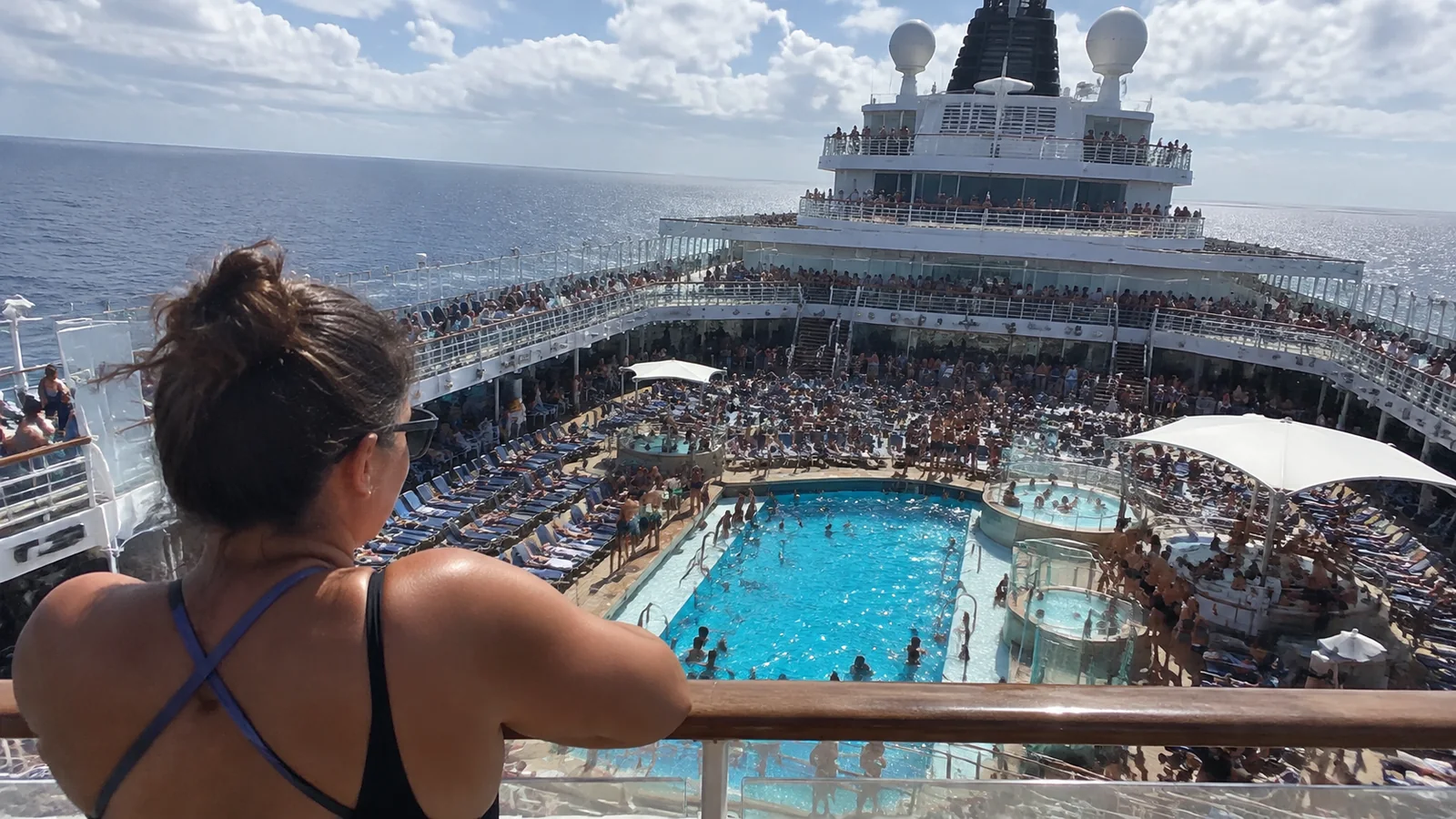 Woman overlooking a crowded cruise ship pool deck