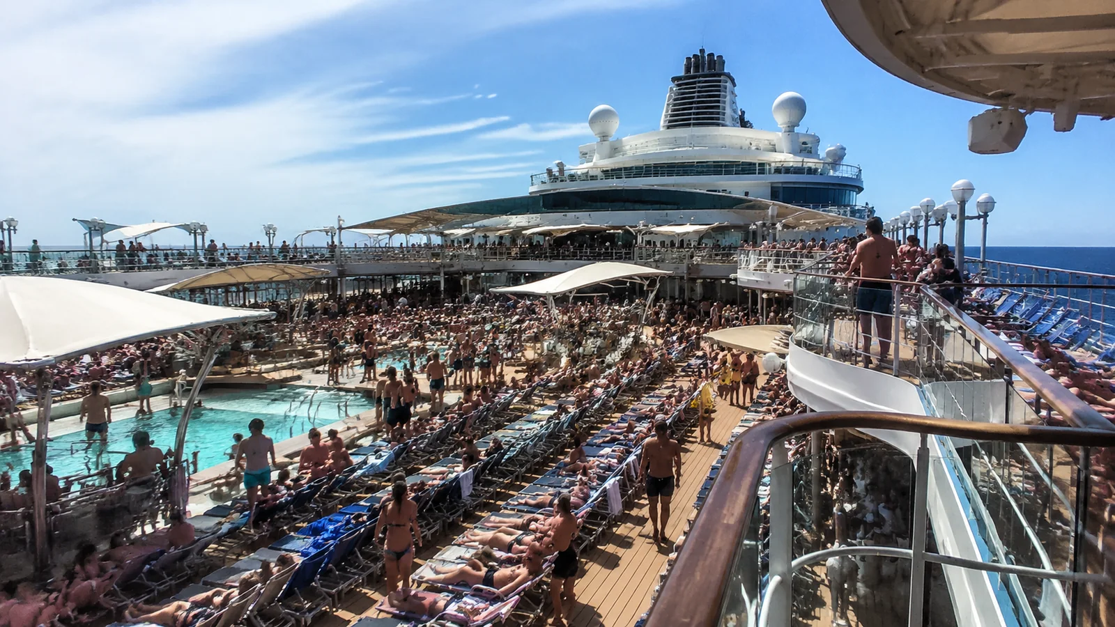 Crowded cruise ship pool and sun decks