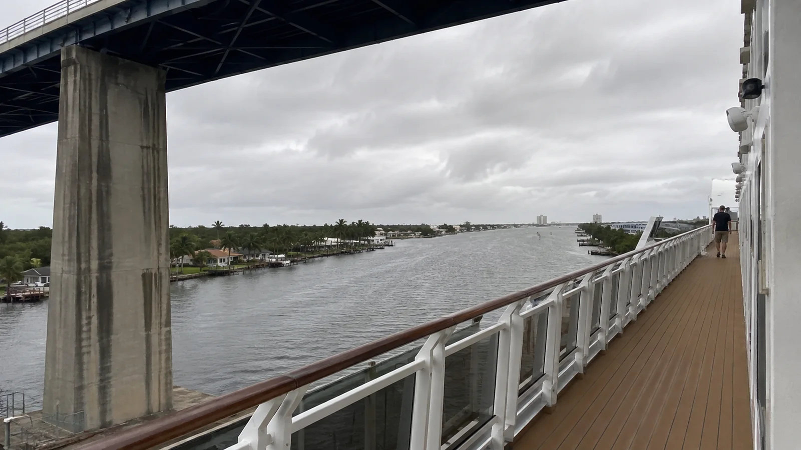 Covered cruise ship promenade passing beneath a bridge