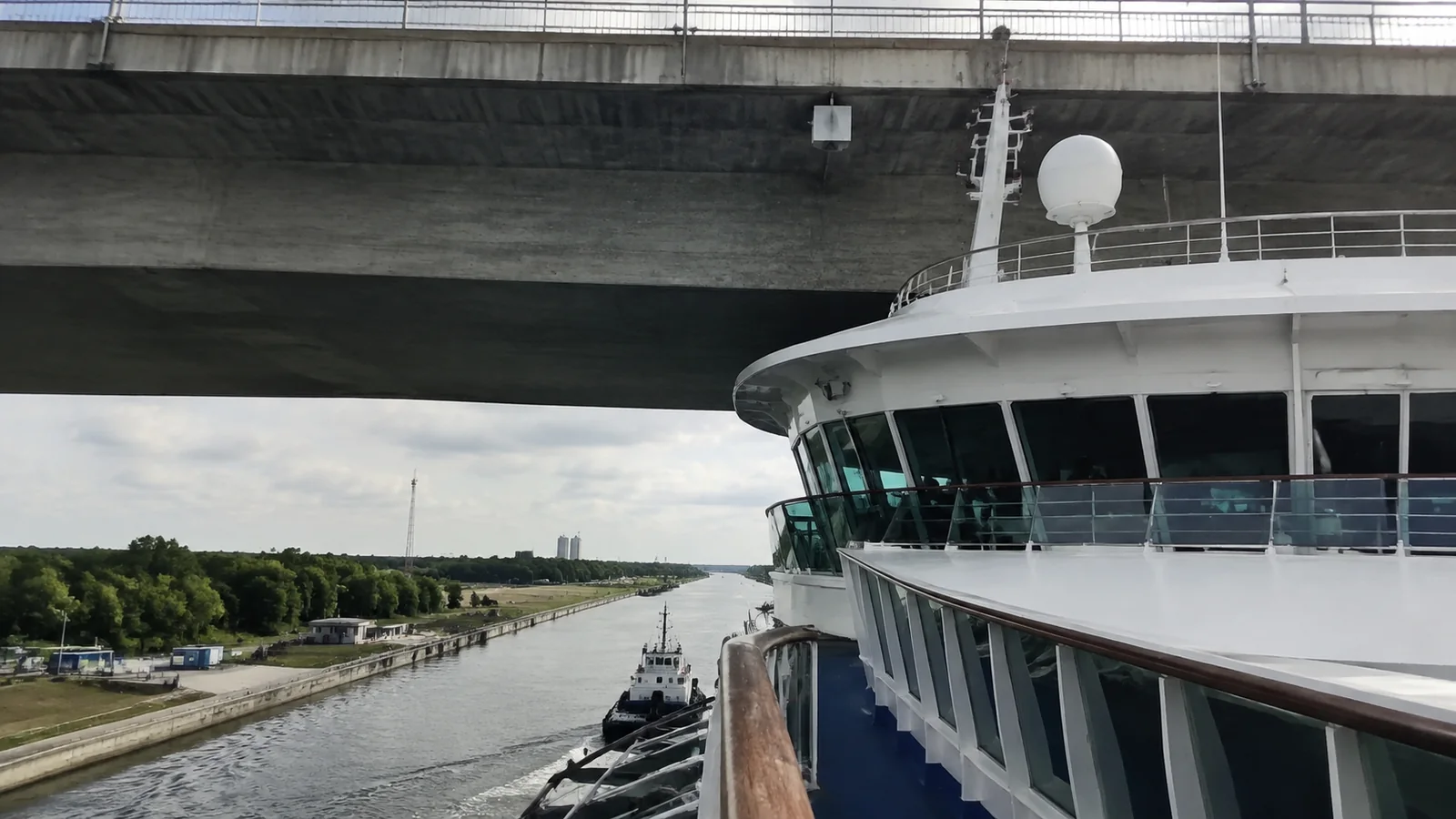 Cruise ship bridge viewed beneath a road bridge