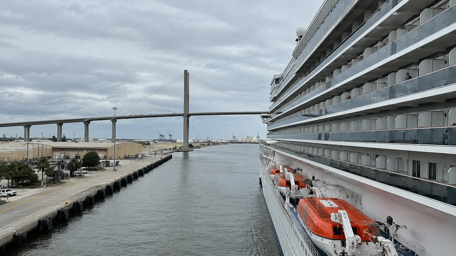 Side of a cruise ship approaching a bridge over a channel