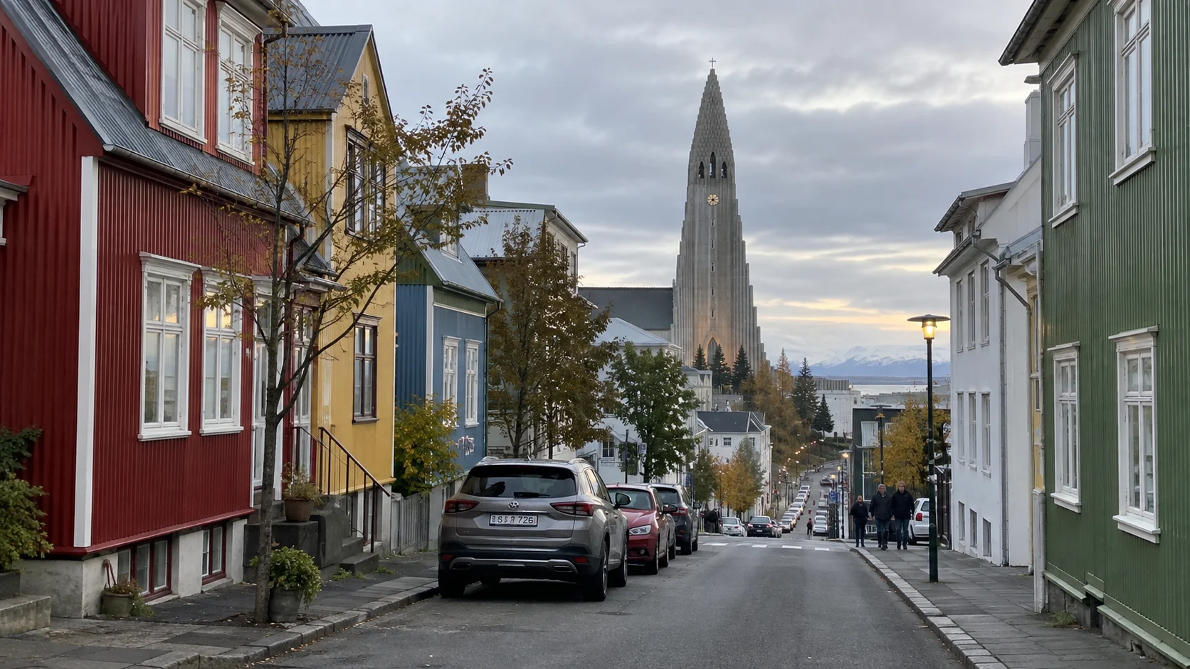 Colorful Reykjavík houses leading toward Hallgrímskirkja beneath an overcast sky.