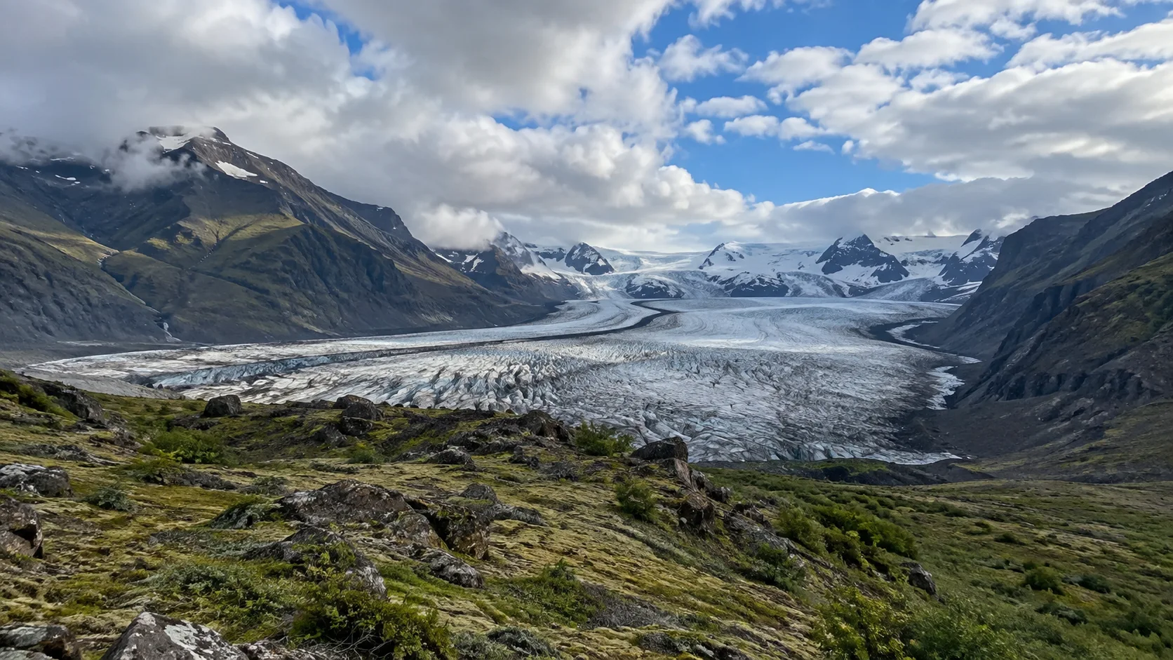 Outlet glacier flowing between dark mountains in Skaftafell.
