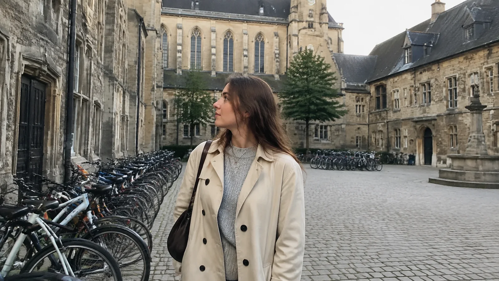 Woman standing beside rows of bicycles in a stone courtyard.
