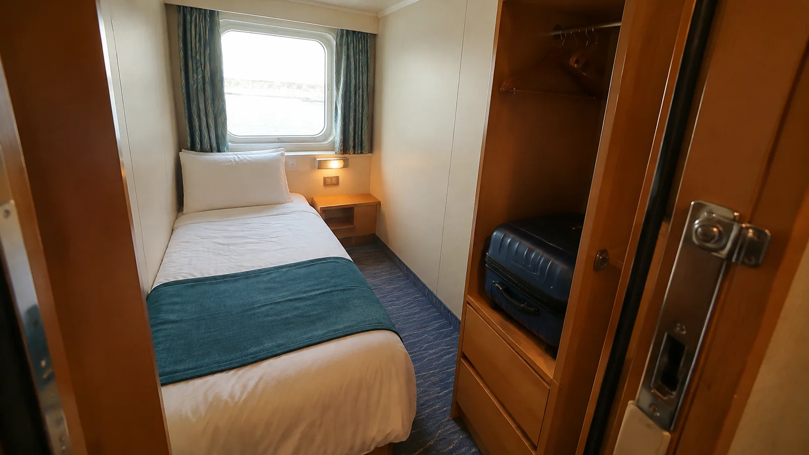 Compact single-bed cabin with a window and wardrobe.