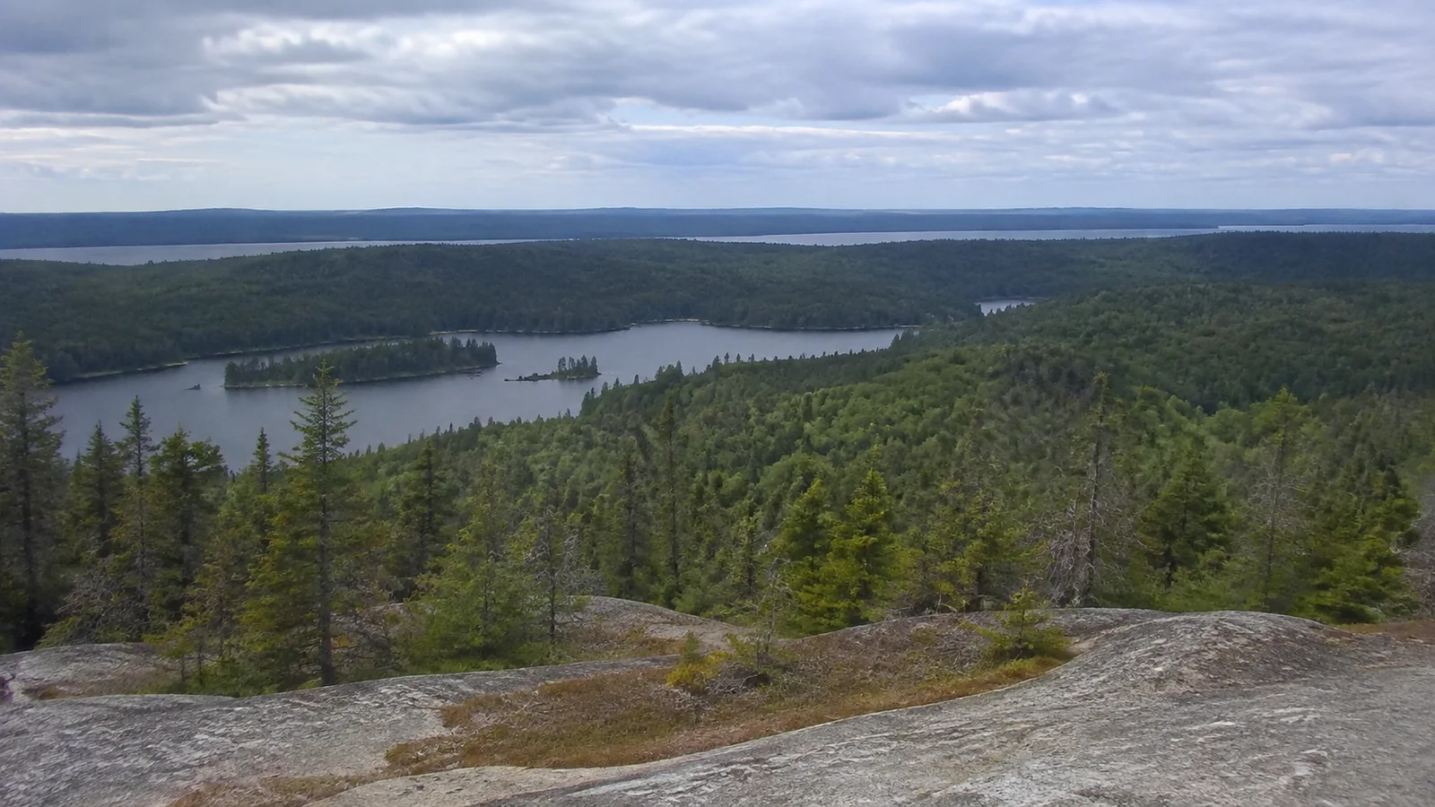 Rocky overlook above forested islands and inland lakes.