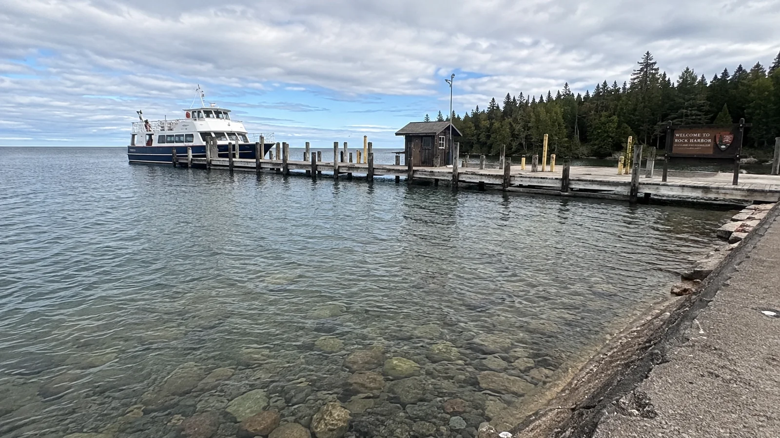 Passenger ferry docked beside a forested lakeshore
